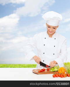 cooking and food concept - smiling female chef, cook or baker chopping vegetables