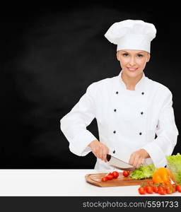 cooking and food concept - smiling female chef, cook or baker chopping vegetables