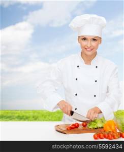 cooking and food concept - smiling female chef, cook or baker chopping vegetables