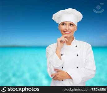 cooking and food concept - smiling female chef, cook or baker dreaming