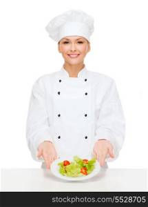 cooking and food concept - smiling female chef, cook or baker with salad on plate