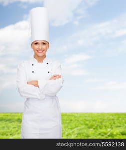 cooking and food concept - smiling female chef with crossed arms