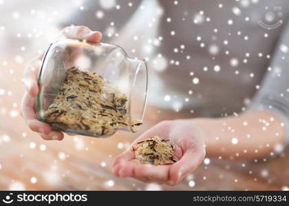 cooking and home concept - close up of female emptying jar with mixture of white and wild black rice