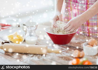 cooking and home concept - close up of female hands kneading dough at home