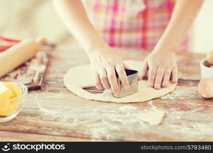 cooking and home concept - close up of female hands making cookies from fresh dough at home