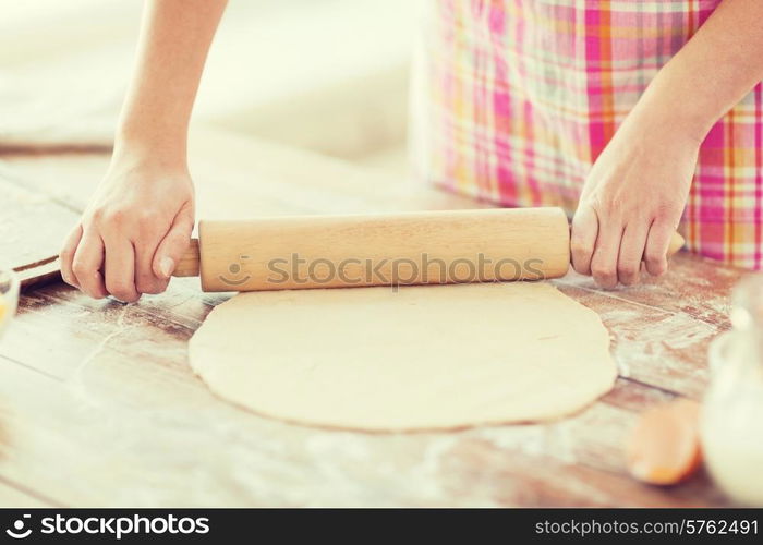 cooking and home concept - close up of female working with rolling-pin