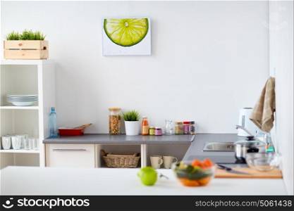 cooking and interior concept - modern home kitchen with kitchenware, food and spices on table. modern home kitchen interior with food on table