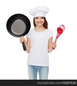 cooking and people concept - smiling little girl in cook hat with ladle, whisk and frying pan