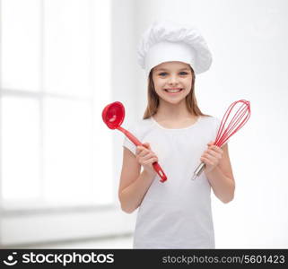 cooking and people concept - smiling little girl in cook hat with ladle and whisk