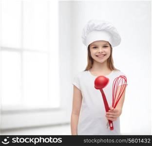 cooking and people concept - smiling little girl in cook hat with ladle and whisk