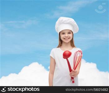cooking and people concept - smiling little girl in cook hat with ladle and whisk