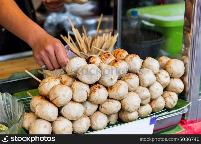cooking, asian kitchen, people and food sale - seller hand with meatballs at street market. seller hand with meatballs at street market