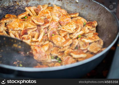 cooking, asian kitchen, sale and food concept - close up of meat frying in wok pan at street market