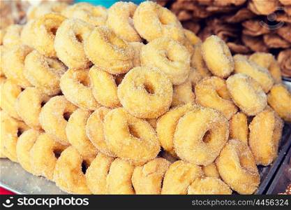 cooking, asian kitchen, sale and food concept - sugared donuts at asian street market