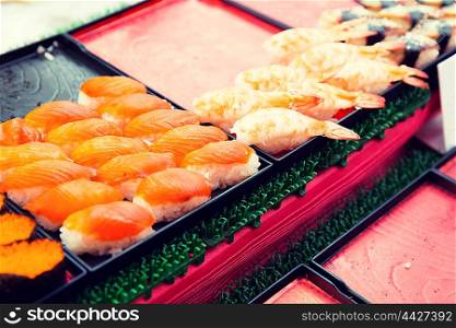 cooking, asian kitchen, sale and food concept - sushi sets at street market