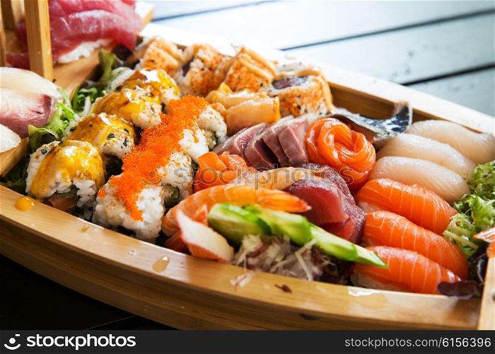 cooking, asian kitchen, seafood, eating and food concept - sushi set at restaurant