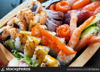 cooking, asian kitchen, seafood, eating and food concept - sushi set at restaurant