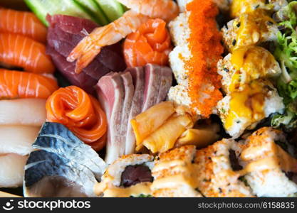 cooking, asian kitchen, seafood, eating and food concept - sushi set at restaurant