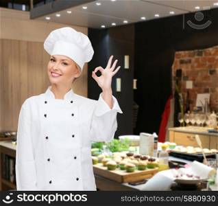 cooking, bakery, gesture and food concept - smiling female chef showing ok hand sign over restaurant kitchen background