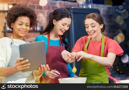 cooking class, friendship, food, technology and people concept - happy women with tablet pc in kitchen. happy women with tablet pc in kitchen