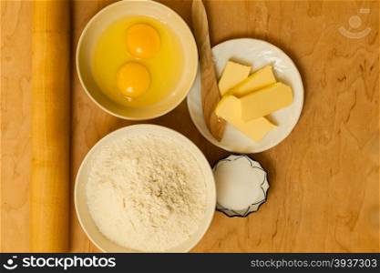 Cooking concept. Preparation for baking, bake ingredients and kitchen tools to make a cake on wooden background top view