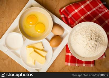 Cooking concept. Preparation for baking, bake ingredients and kitchen tools to make a cake on wooden background top view