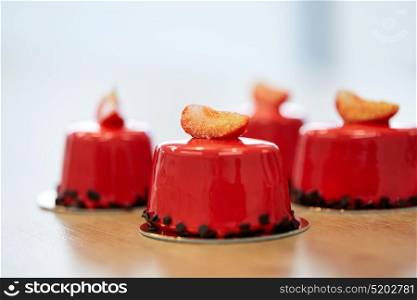cooking, confectionery, baking and food concept - strawberry mirror glaze cakes. strawberry mirror glaze cakes at pastry shop