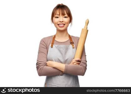 cooking, culinary and people concept - happy smiling female chef in apron with wooden rolling pin over white background. happy woman in apron with wooden rolling pin