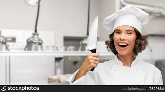 cooking, culinary and people concept - happy smiling female chef in toque with knife over restaurant kitchen background. smiling female chef in toque with kitchen knife