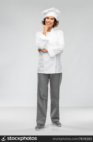 cooking, culinary and people concept - happy smiling female chef in toque over grey background. smiling female chef in toque