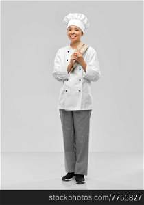 cooking, culinary and people concept - happy smiling female chef in white jacket with kitchen towel on shoulder over grey background. smiling female chef in jacket with kitchen towel