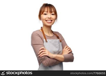 cooking, culinary and people concept - happy smiling female chef or waitress in apron with crossed arms over white background. happy smiling woman, chef or waitress in apron