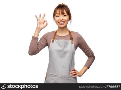 cooking, culinary and people concept - happy smiling female chef or waitress in apron showing ok gesture over white background. happy female chef or waitress showing ok gesture