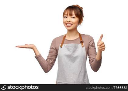 cooking, culinary and people concept - happy smiling female chef or waitress in apron holding something imaginary on hand and thumbs up sign over white background. happy female chef or waitress holding something