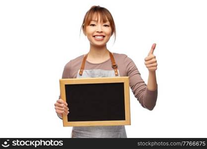 cooking, culinary and people concept - happy smiling female chef or waitress in apron with chalkboard showing thumbs up gesture over white background. woman in apron with chalkboard showing thumbs up