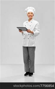 cooking, culinary and people concept - happy smiling female chef with tablet pc computer over grey background. smiling female chef with tablet computer