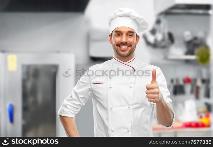 cooking, culinary and people concept - happy smiling male chef in toque showing thumbs up over restaurant kitchen background. smiling male chef in toque showing thumbs up