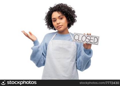 cooking, culinary and people concept - woman in apron holding closed sign over white background. woman in apron holding closed sign