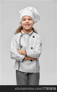 cooking, culinary and profession concept - happy smiling little girl in chef&rsquo;s toque and jacket over grey background. smiling little girl in chef&rsquo;s toque and jacket