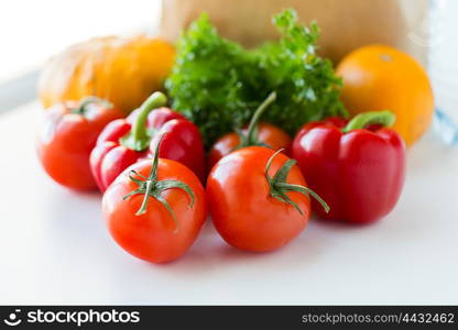 cooking, diet, vegetarian food and healthy eating concept - close up of fresh ripe juicy vegetables and greens on kitchen table at home