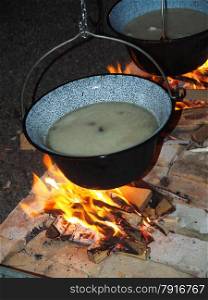 cooking fish soup in a kettle on the fire