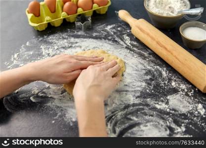 cooking food and culinary concept - close up of hands making shortcrust pastry dough on table. hands making shortcrust pastry dough on table
