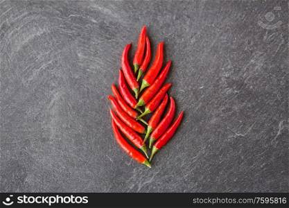 cooking, food and culinary concept - red chili or cayenne pepper on slate stone surface. red chili or cayenne pepper on slate stone surface