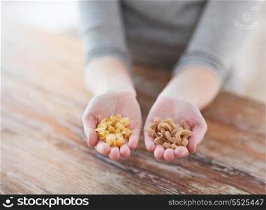 cooking, food and home concept - cloes up of female cupped hands with different pasta variations