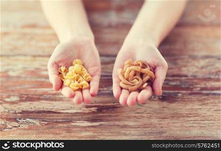 cooking, food and home concept - cloes up of female cupped hands with different pasta variations