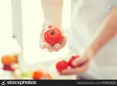 cooking, food and home concept - close up of male hands holding tomatoes