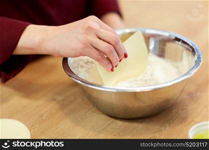 cooking food, baking and people concept - chef with spatula stirring flour in bowl and making batter or dough. chef with flour in bowl making batter or dough