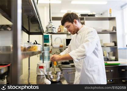 cooking food, baking and people concept - happy male chef cook with flour breaking eggs into bowl at restaurant or bakery kitchen. happy male chef cooking food at restaurant kitchen