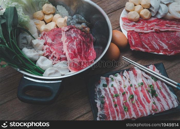 Cooking food by put a flesh beef, pork, egg and vegetable in to a hot pot for make a sukiyaki or shabu at japanese shabu buffet restaurant. Cooking food in hot pot for make sukiyaki or shabu