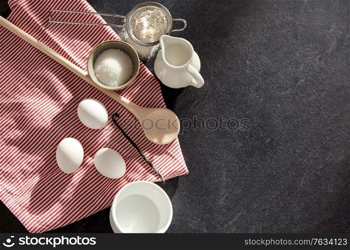 cooking food, culinary and recipe concept - eggs, milk, flour, wooden spoon and vanilla extract on table. eggs, sugar, milk, flour, spoon and vanilla